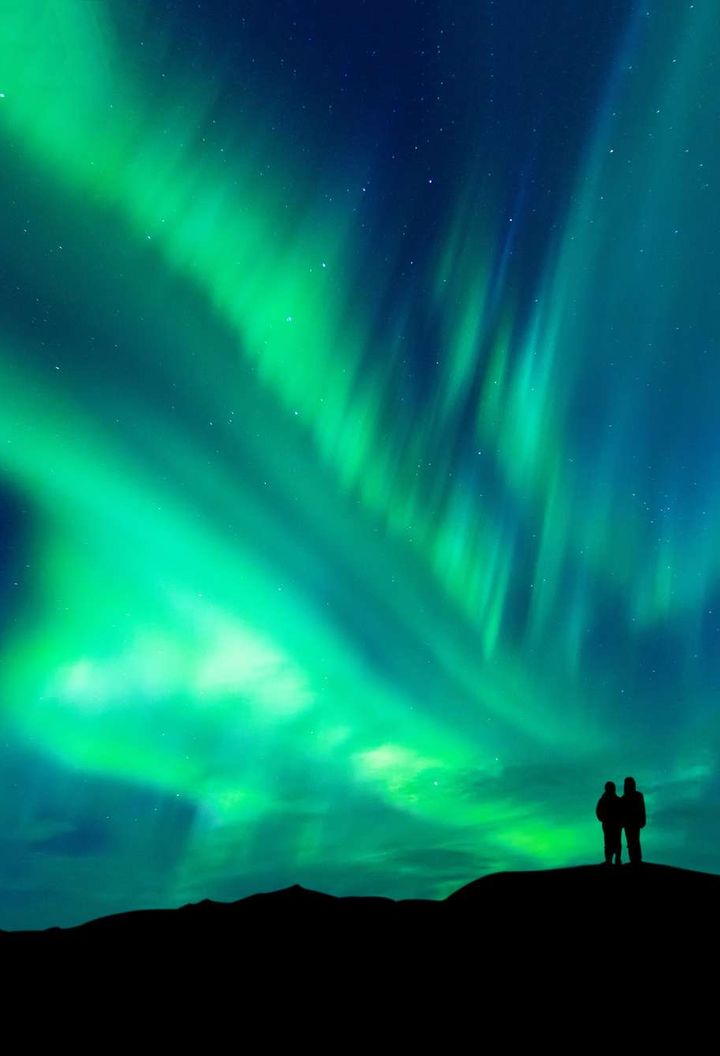 swedish lapland couple watching aurora borealis istk